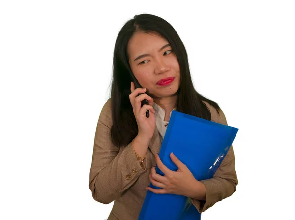 corporate business stress portrait of young attractive upset and stressed executive Asian Korean woman talking on mobile phone tired and unhappy holding paperwork