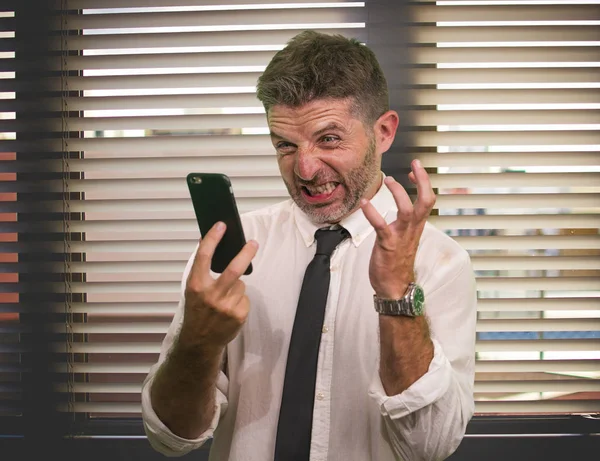 Vállalati üzleti és irodai életmód portré fiatal stresszes és feldúlt vezető férfi dolgozik stressz alatt nézett dühös a mobiltelefon dühös és dühös a munkahelyen — Stock Fotó