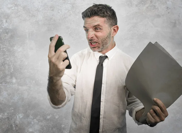 Corporate business and office lifestyle portrait of young stressed and upset executive man working under stress looking angry to mobile phone furious and angry at workplace — ストック写真