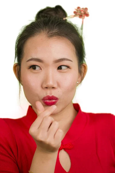 Geleneksel çörek saç stili ve kırmızı elbiseli, beyaz üzerinde izole edilmiş aşk parmakları işareti yapan güzel ve tatlı Asyalı bir Çinli kadının dikey portresi. — Stok fotoğraf