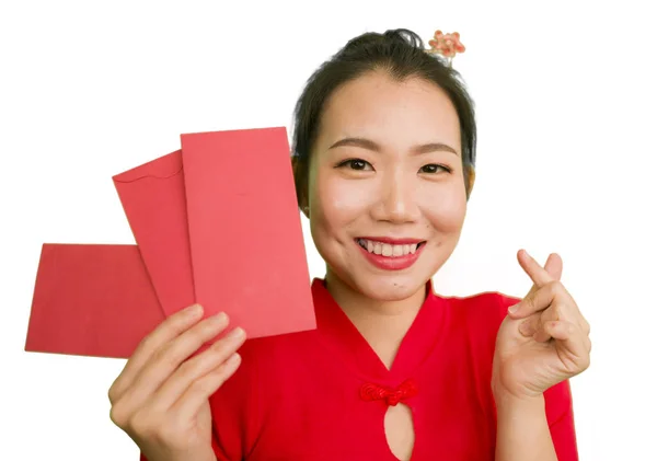 Jong mooi en gelukkig aziatisch Chinees vrouw in traditionele Nieuwjaar rood jurk en haar broodje met rode zak enveloppen met geld als zegen van vrienden en familie — Stockfoto