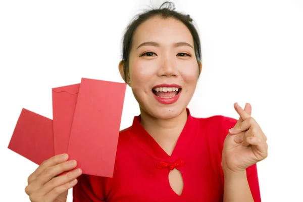 Jong gelukkig en mooi aziatische Chinese vrouw in traditionele Nieuwjaar rode jurk en haar broodje met rode zak enveloppen met geld als zegen van vrienden en familie — Stockfoto