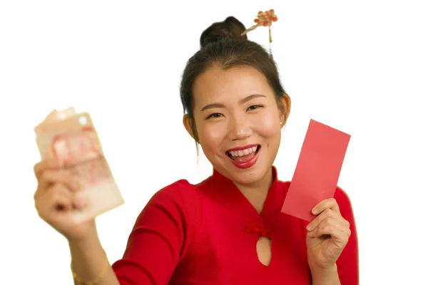 Jong gelukkig en mooi aziatische Chinese vrouw in traditionele Nieuwjaar rode jurk en haar broodje met rode zak enveloppen met geld als zegen van vrienden en familie — Stockfoto