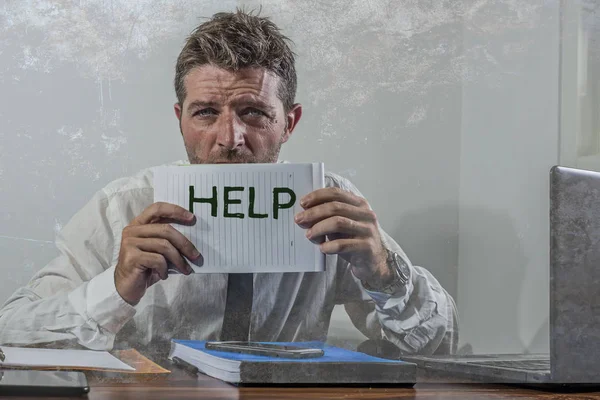 Corporate business worker in stress - young attractive stressed and desperate businessman holding help sign overworked and overwhelmed working at office computer desk frustrated — Stock Photo, Image