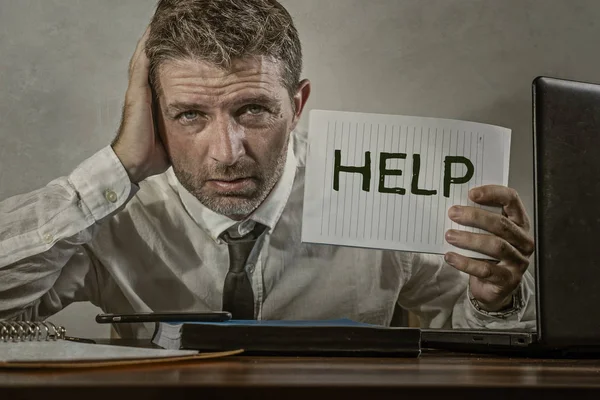 corporate business worker in stress - young attractive stressed and desperate businessman holding help sign overworked and overwhelmed working at office computer desk frustrated