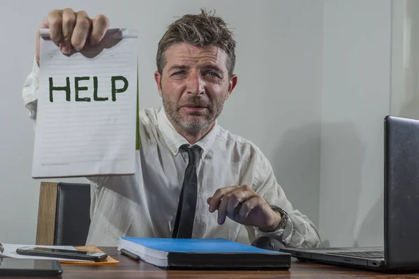 corporate business worker in stress -  attractive stressed and desperate businessman holding sign crying for help overworked and overwhelmed working at office computer desk