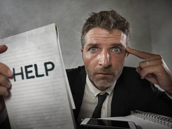 Business lifestyle portrait of depressed and overwhelmed attractive man working at office computer desk in stress holding notepad as help sign feeling frustrated and exhausted — 스톡 사진