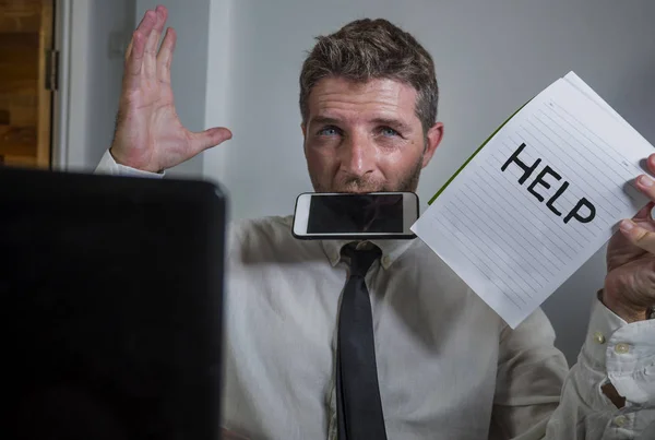 Estilo de vida de negocios retrato de hombre atractivo deprimido y abrumado que trabaja en el escritorio de la oficina en el estrés sujetando el bloc de notas como signo de ayuda sentirse frustrado y agotado —  Fotos de Stock