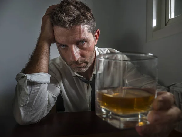 Alcohólico hombre en perder corbata beber alcohol desesperado y desperdiciado mirando vaso de whisky pensativo borracho y deprimido luchando contra su adicción a la bebida — Foto de Stock