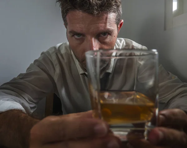 Alcolizzato uomo in perdere cravatta bere alcol disperato e sprecato guardando bicchiere di whisky riflessivo ubriaco e depresso combattere la sua dipendenza da bere — Foto Stock