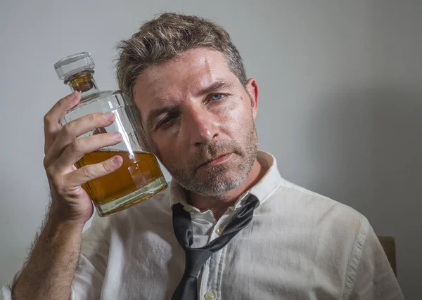 Alcolizzato uomo in perdere cravatta bere alcol disperato e sprecato in possesso di bottiglia di whisky sentirsi ubriaco e depresso bere per eludere la realtà in grunge modificare — Foto Stock