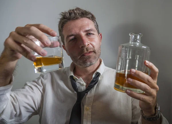 Dramático retrato de hombre de 30 a 40 años en corbata perdida bebiendo alcohol desesperado y desperdiciado sosteniendo botella de whisky sintiéndose borracho y deprimido bebiendo para evadir la realidad —  Fotos de Stock