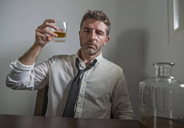 Portrait of 30s to 40s alcoholic  man in lose necktie drinking desperate holding whiskey glass thoughtful drunk and depressed completely wasted in alcohol addiction concept — 스톡 사진