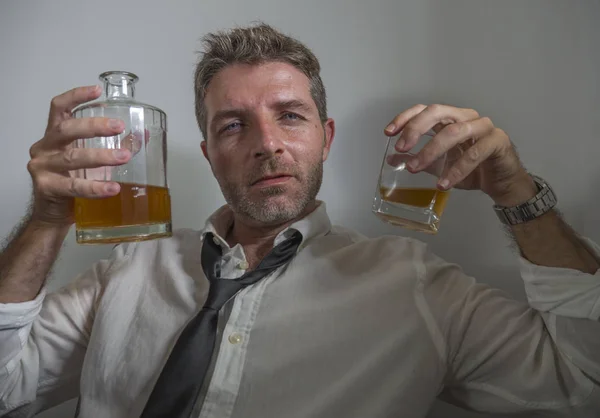 Portrait of 30s to 40s alcoholic  man in lose necktie drinking desperate holding whiskey glass thoughtful drunk and depressed completely wasted in alcohol addiction concept — 스톡 사진