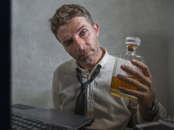 Viciado em álcool empresário - retrato dramático de homem alcoólico em perder gravata beber na mesa de escritório enquanto trabalhava desperdiçado e bagunçado segurando garrafa de uísque bêbado e deprimido — Fotografia de Stock