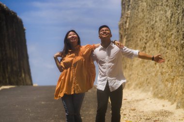 Genç mutlu ve güzel Asyalı Çinli çift açık havada romantik bir yolculuk yapıyorlar. Kayalık kaya yolunda yürüyorlar. Birlikte manzarayı keşfediyorlar.