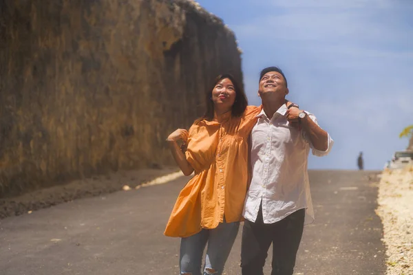 Young happy and beautiful Asian Chinese couple in love enjoying outdoors romantic journey walking in cliff rock road exploring the landscape together in holidays travel adventure — 스톡 사진