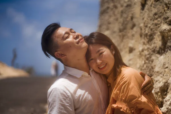 Young happy and beautiful Asian Korean couple in love enjoying outdoors romantic journey playing sweet in cliff rock road exploring together in holidays travel adventure and wanderlust — 스톡 사진