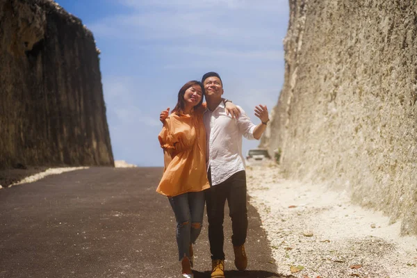 Молоде щасливе і красиве корейське подружжя закоханих насолоджується романтичною подорожжю на відкритому повітрі по скелях, досліджуючи пейзаж разом у відпустці пригод. — стокове фото