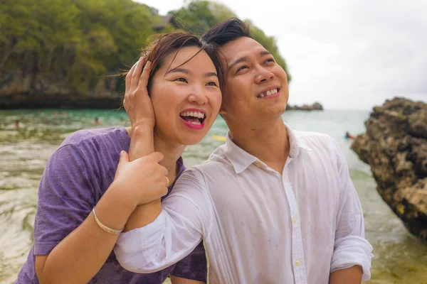 Summer holidays lifestyle portrait of young beautiful and sweet Asian Chinese couple in love walking on the beach together enjoying honeymoon trip in the beach smiling cheerful — 스톡 사진