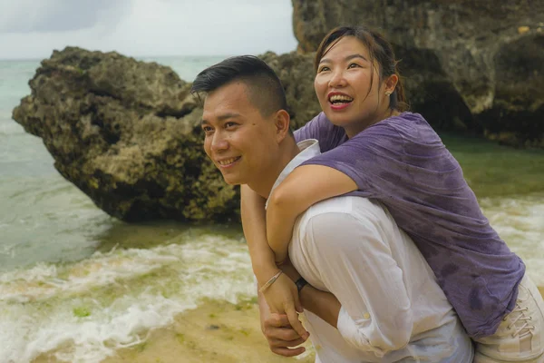 Sommar semester livsstil porträtt av unga vackra och söta asiatiska kinesiska par kär promenader på stranden tillsammans njuter smekmånad resa på stranden ler glad — Stockfoto