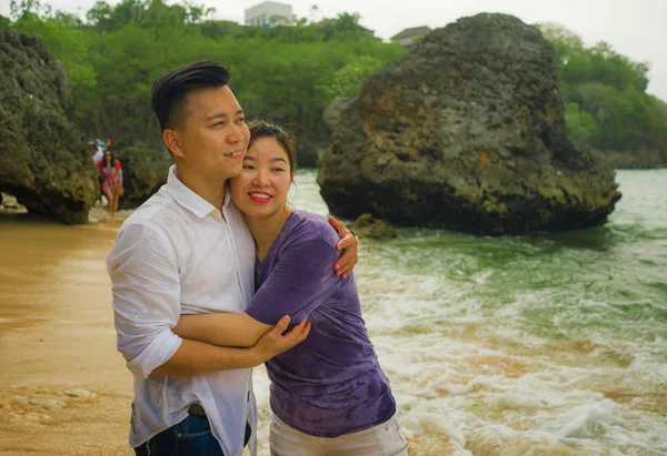 Summer holidays lifestyle portrait of young beautiful and sweet Asian Chinese couple in love walking on the beach together enjoying honeymoon trip in the beach smiling cheerful — 스톡 사진