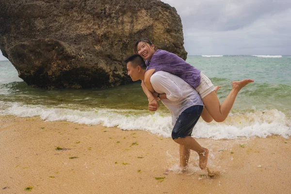 Sommar semester livsstil porträtt av unga vackra och söta asiatiska koreanska par kär promenader på stranden tillsammans njuter smekmånad resa på stranden ler glad — Stockfoto