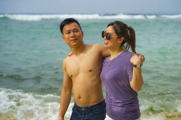 Summer holidays lifestyle portrait of young beautiful and sweet Asian Korean couple in love walking on the beach together enjoying honeymoon trip in the beach smiling cheerful — 스톡 사진