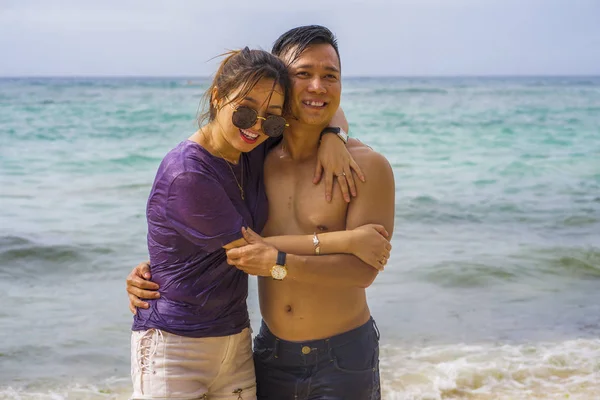 Summer holidays lifestyle portrait of young beautiful and sweet Asian Korean couple in love walking on the beach together enjoying honeymoon trip in the beach smiling cheerful — 스톡 사진