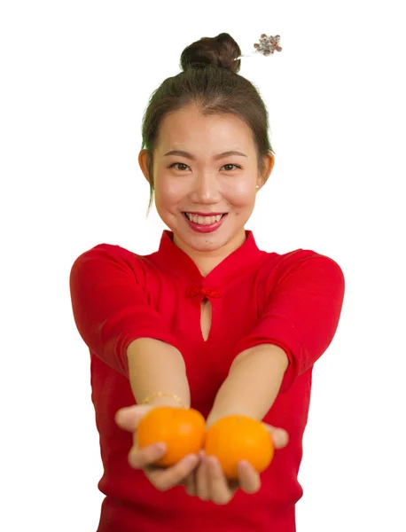 Jovem bela e feliz mulher asiática no tradicional ano novo chinês vestido vermelho segurando frutas laranja como símbolo de prosperidade isolada no fundo branco — Fotografia de Stock