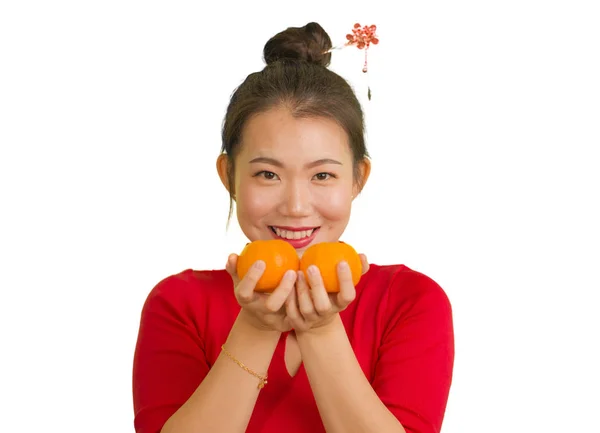 Jong mooi en gelukkig aziatisch vrouw in traditionele Chinees Nieuwjaar rood jurk met oranje fruit als symbool van welvaart geïsoleerd op witte achtergrond — Stockfoto