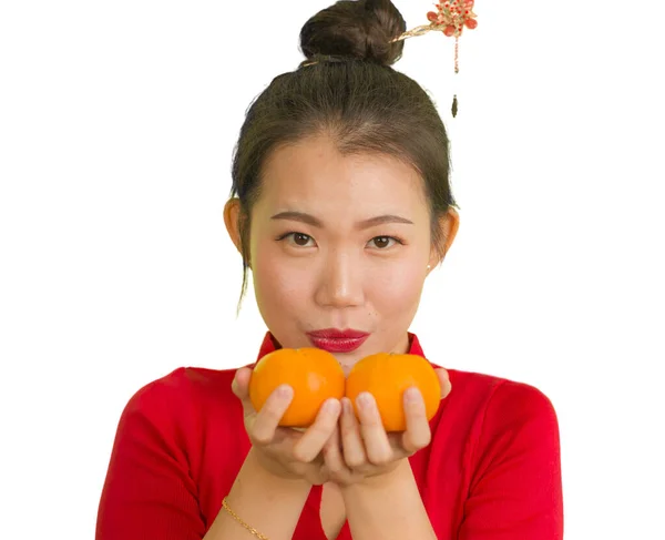 Jong mooi en gelukkig aziatisch vrouw in traditionele Chinees Nieuwjaar rood jurk met oranje fruit als symbool van welvaart geïsoleerd op witte achtergrond — Stockfoto