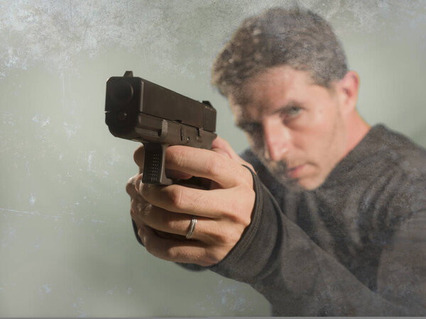 гранж кинематографический портрет привлекательного и опасного наемника или спецназовца спецслужб в действии, направленный на преступную толпу и преступный образ жизни
