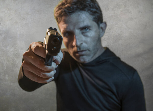 гранж кинематографический портрет привлекательного и опасного наемника или спецназовца спецслужб в действии, направленный на преступную толпу и преступный образ жизни
