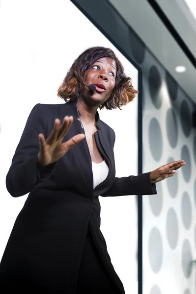 Jonge aantrekkelijke en zelfverzekerde succesvolle zwarte Afro-Amerikaanse zakenvrouw met headset spreken bij corporate bedrijf coaching en training in vergaderzaal — Stockfoto