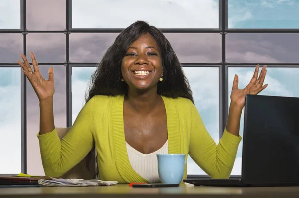 幸せで魅力的な黒人アフリカ系アメリカ人のビジネス女性はオフィスのコンピュータデスクで働く自信に満ちた笑顔で企業の仕事の成功を祝うビジネス女性 — ストック写真