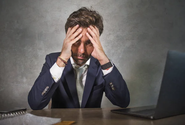 Deprimido y estresado atractivo empresario hispano en traje y corbata trabajando agotado en la oficina escritorio de la computadora frustrado y sobrecargado de trabajo como ejecutivo en problemas — Foto de Stock