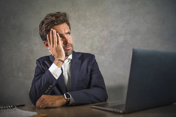 Déprimé et stressé attrayant homme d'affaires hispanique en costume et cravate de travail épuisé au bureau ordinateur frustré et surchargé de travail en tant qu'homme d'affaires en difficulté — Photo