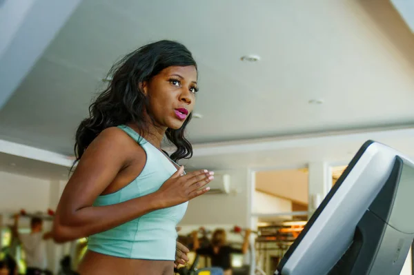 Indoor fitness center lifestyle ritratto di giovane donna afro americana attraente e sudata che si allena duramente in palestra facendo tapis roulant che corre allenamento nella cura del corpo — Foto Stock