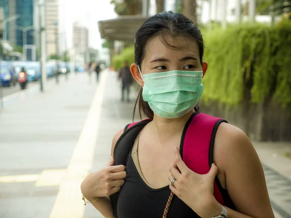 Якась вродлива і приваблива жінка з Китаю, яка ходить по міській вулиці, носить захисну маску від епідемії вірусу китайської корони. — стокове фото