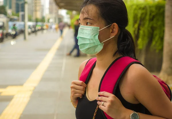 Якась вродлива і приваблива жінка з Китаю, яка ходить по міській вулиці, носить захисну маску від епідемії вірусу китайської корони. — стокове фото