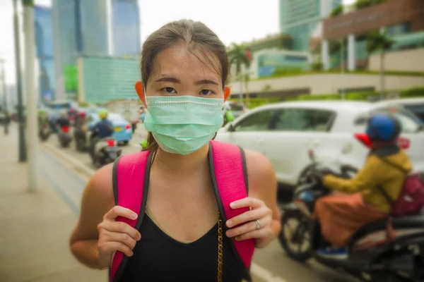 Joven hermosa y atractiva asiática estudiante china que camina por la calle de la ciudad con máscara facial protectora contra el brote epidémico del virus Corona de China —  Fotos de Stock