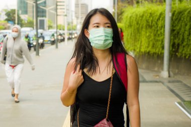 Çin Corona virüs salgınına karşı koruyucu maske takmış yakışıklı ve çekici Asyalı Çinli bir kadın.