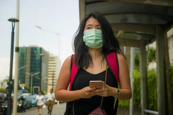 Joven hermosa y atractiva asiática estudiante china que camina por la calle de la ciudad con máscara facial protectora contra el brote epidémico del virus Corona de China —  Fotos de Stock