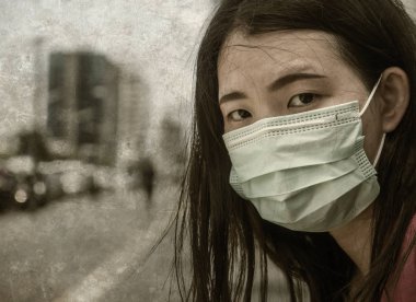Çin Corona virüs salgınına karşı koruyucu maske takmış yakışıklı ve çekici Asyalı Çinli bir kadın.