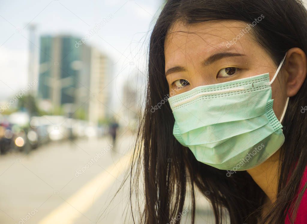 young beautiful and attractive Asian Chinese student woman walking on city street wearing protective facial mask against China Corona virus epidemic outbreak