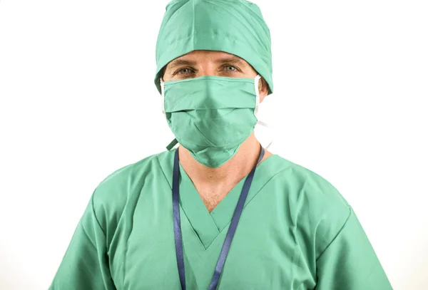 Корпоративный портрет привлекательного и успешного врача клиники, уверенно улыбающегося в зеленой медицинской одежде и защитной маске для лица и буффантной кепке — стоковое фото