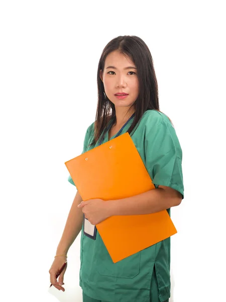 Young beautiful and confident Asian Chinese medicine doctor or hospital nurse woman smiling happy holding medical reports clipboard wearing scrubs  in health care concept — 스톡 사진