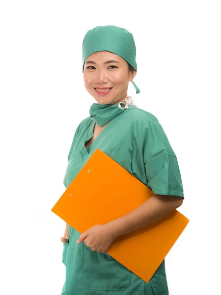 Молодая красивая и уверенная в себе азиатская корейская медицина врач или больница медсестра женщина улыбается счастливо держа медицинские отчеты буфер в шляпе хирурга и скрабы в концепции здравоохранения — стоковое фото