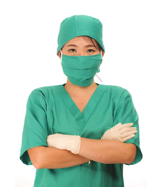 Junge schöne und glückliche Ärztin oder Chefkrankenschwester in grünem Peeling und Chirurgenmütze und Maske mit schützenden Latexhandschuhen — Stockfoto